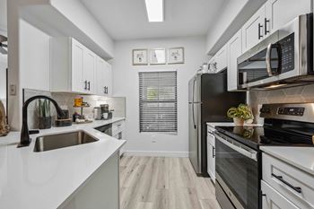 a kitchen with white cabinets and black appliances
